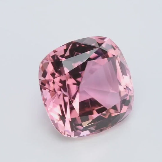 The 45.84 ct Pink Tourmaline from Joyaux™ Genève is not merely a jewel, but a radiant testament to nature's most exquisite artistry. With dimensions of 20.80 x 20.80 x 15.90 mm, this square cushion-shaped marvel glows with a romantic pink hue, reminiscent of the first blush of dawn. Mined from the fertile soils of Nigeria's Cross River State, this tourmaline is a rare treasure, its origins as compelling as a timeless novel.